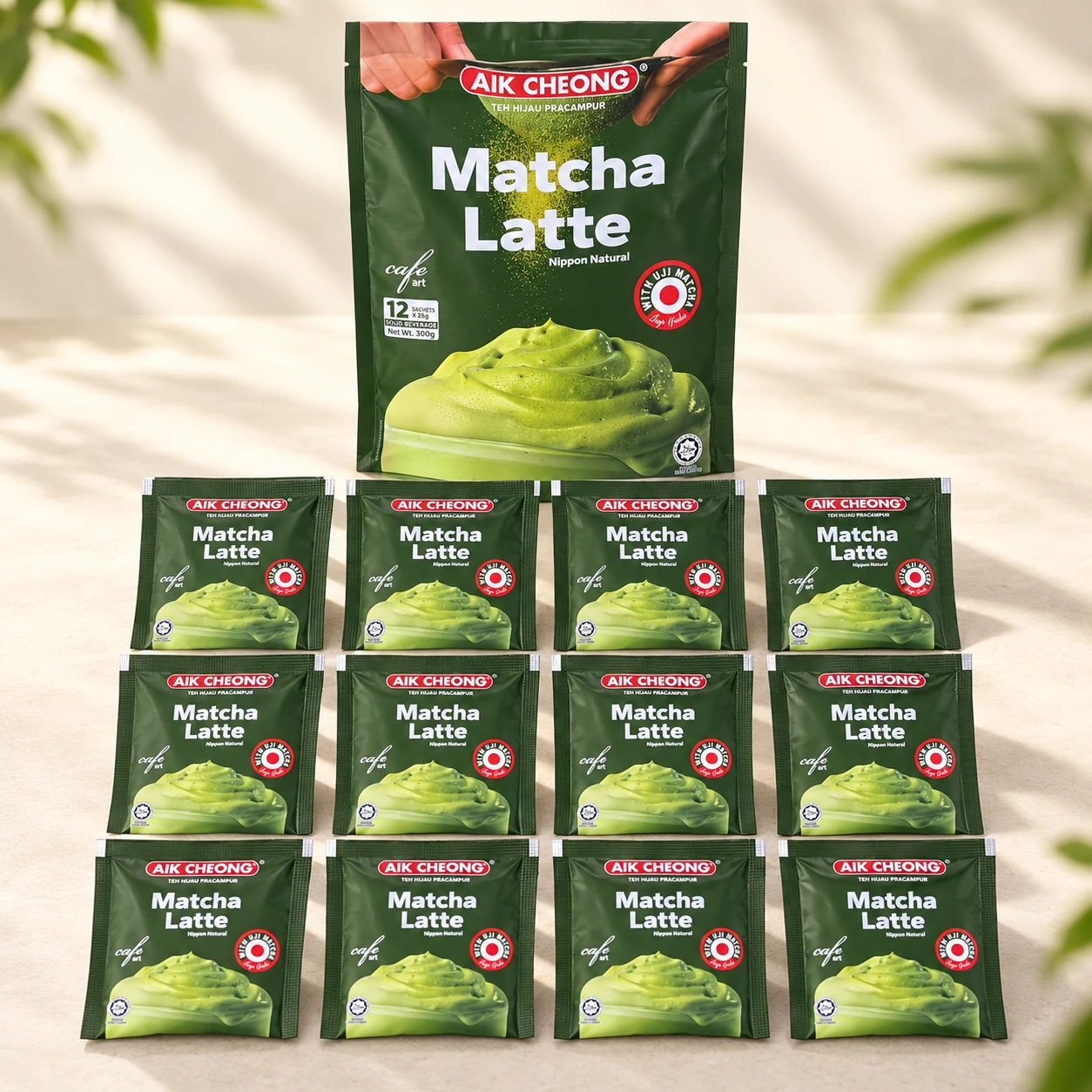 একটি বড় AIK CHEONG Matcha Latte প্যাকের সামনে তিন সারিতে সাজানো ১২টি ছোট স্যাশে